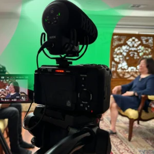 A professional studio setup for a legacy interview featuring a single subject, cinematic lighting, and a high-definition microphone.