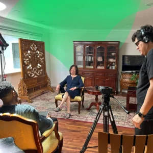 Professional filmmaker setting up a multi-camera interview for a family heritage documentary on location.